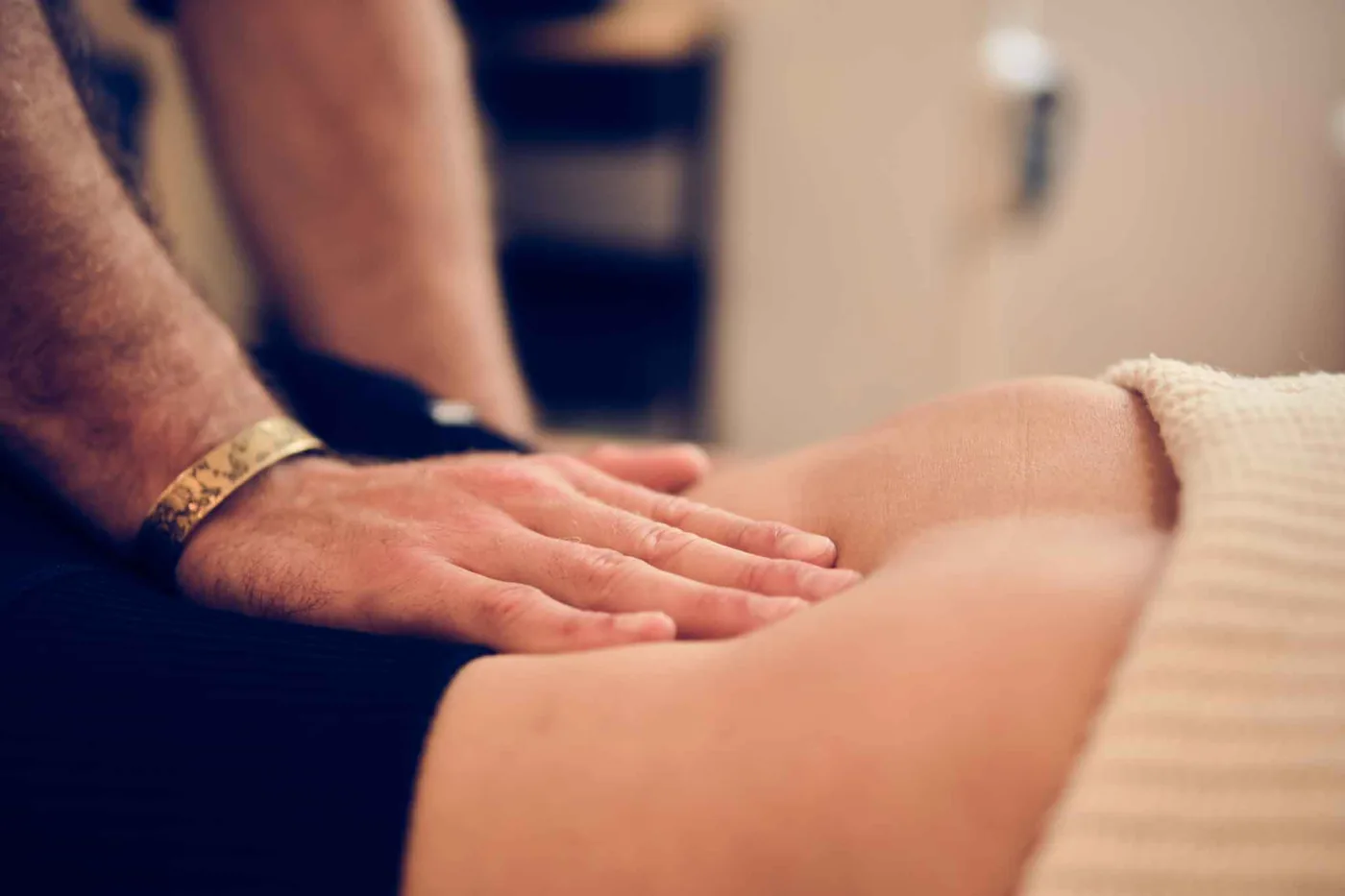 Nahaufnahme: Eine Hand tastet behutsam den Bauchraum ab
